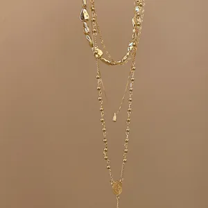 Detail view of gold layered necklace set featuring irregular water-drop pendants