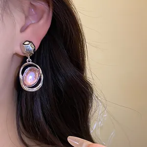 Detailed macro shot of vintage acrylic oval pendant earring with interlocking silver rings