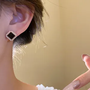Close-up of retro court style square stud earring with a black stone and pearls