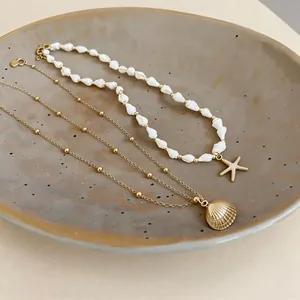 Détail de colliers de style plage avec pendentifs coquillage et étoile de mer sur plat