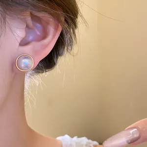 Close-up detail of an elegant vintage palace style cat's eye stud earring on ear