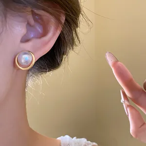 Detailed close-up showing an elegant vintage golden earring with a cat eye pearl stone