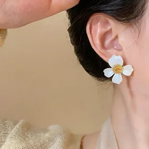 Dettaglio ravvicinato di un elegante orecchino a fiore bianco con pistillo dorato