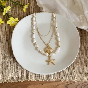Vue détaillée d'un collier multi-rangs de plage avec pendentifs étoile de mer et coquillage dorés.