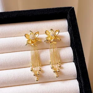 Detailansicht der 18k vergoldeten Blumenohrringe mit eleganten Zirkonia-Quasten-Anhängern.