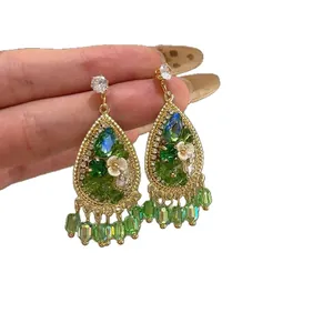 Elegant waterdrop earrings with green crystals and floral details in gold finish