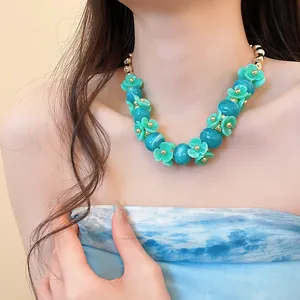 Vue détaillée d'un collier de fleurs turquoise avec des perles bleues marbrées.