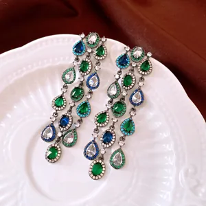 Nahaufnahme eleganter Zirkon-Quastenohrringe mit grünen und blauen Tropfensteinen