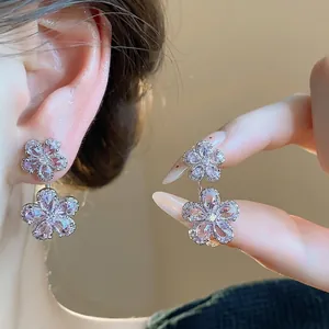 Elegant double flower stud earrings with sparkling pink zircon stones worn on ear for women