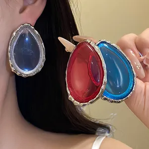 Vibrant water drop resin earrings in red and blue with textured silver border.