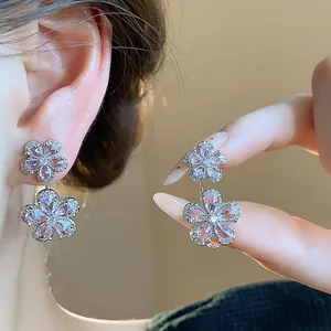 Detailed close-up of sparkling pink zircon flower earrings with silver needle post.