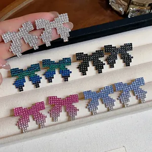 Close-up macro of pixelated bow earrings with vibrant gradient rhinestone inlay