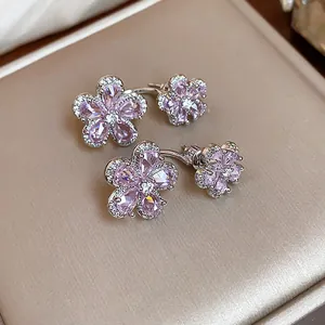 Detail view of shimmering pink zircon flower-shaped silver stud earrings on a display