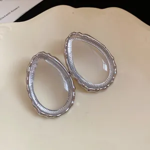 Macro view showing the textured silver rim and clear resin of the teardrop stud earrings.