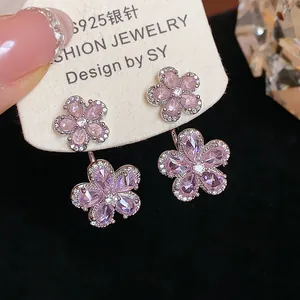 Macro detail of purple zircon flower stud earrings featuring S925 silver needles.