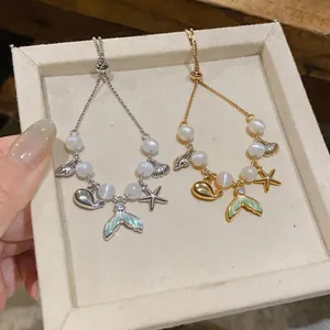 Macro view of two bracelets featuring starfish, mermaid tail charms, and opal beads.