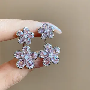 Close-up detail of exquisite pink and clear zircon floral earrings for women.