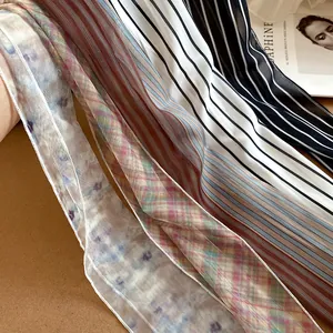 Macro view showing multiple prints and delicate mesh texture of long skinny neck scarves.