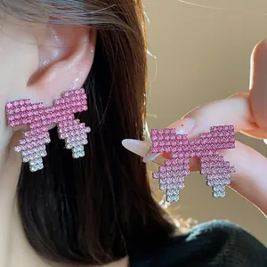 Close-up of pink gradient rhinestone bow earrings with pixelated edges