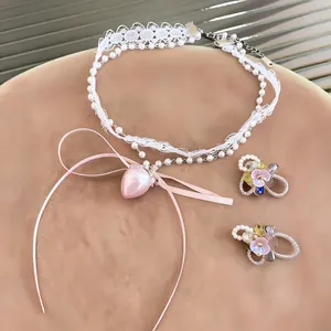 Close-up of sweet lace choker with pink strawberry pendant and floral earrings set