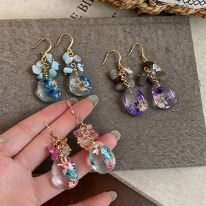 Elegant handmade resin drop earrings with real dried flowers and natural stones style.