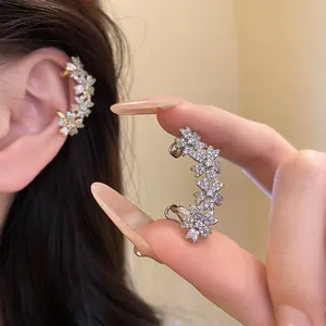 Close-up of sparkling 14k gold plated zirconia floral ear cuff for non-pierced ears