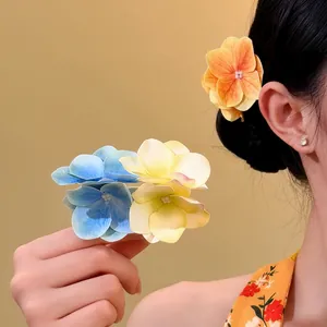 Vista dettagliata dei fermagli per capelli a fiore di ortensia blu e gialli su modella