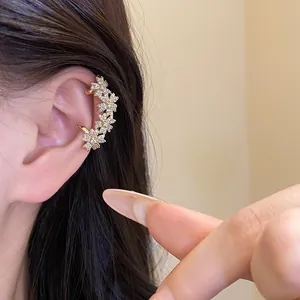 Detailed close-up showing a 14k gold plated cubic zirconia floral ear cuff on model ear