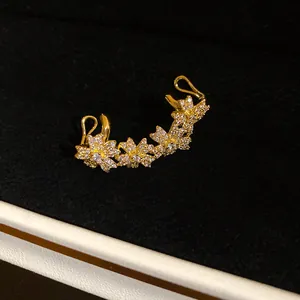 Detail view of 14K gold plated flower ear cuff featuring sparkling cubic zirconia.
