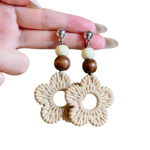 Handmade bohemian flower rattan woven earrings with wooden beads for beach vacations.