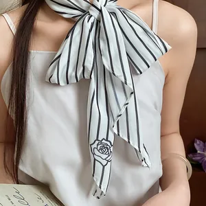 Close-up of white mesh striped scarf necklace tied in a bow around neck