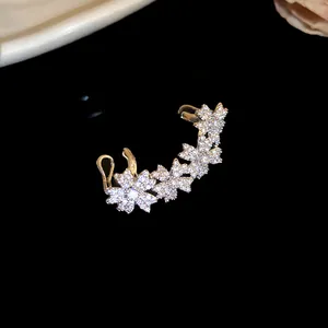 Close-up of elegant 14k gold-plated zircon flower ear cuff earring on black background