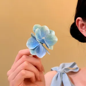 Primo piano di un fermaglio per capelli a forma di fiore blu con petali sfumati realistici
