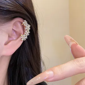 Detail view of 14k gold plated flower ear cuff with sparkling zircons for women