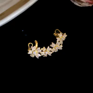 Detailed close-up of 14k gold plated flower ear cuff with sparkling cubic zirconia
