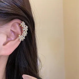 Detailed view of a sparkling 14k gold plated zircon flower ear cuff worn on ear