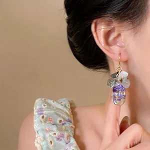 Detail view of elegant New Chinese style resin earrings with purple floral inside