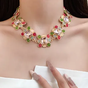 Close-up of a French vintage necklace with colorful crystals and resin stones on a model.