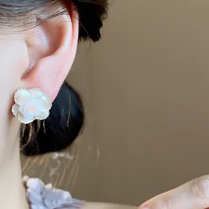 Vue rapprochée d'une élégante boucle d'oreille fleur en résine avec un détail de rose au centre