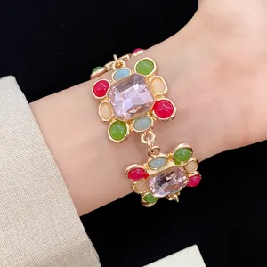 Close-up of vintage geometric bracelet with pink resin stone and colorful beads
