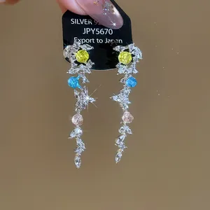 Gros plan de boucles d'oreilles pendantes élégantes avec feuilles en zircon