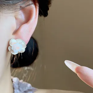 Vue détaillée de près d'une élégante boucle d'oreille fleur en résine blanche