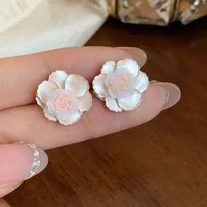 Gros plan détaillé sur des boucles d'oreilles élégantes en résine fleur de camélia
