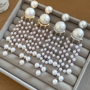 Detailed view of elegant pearl tassel drop earrings in a grey velvet jewelry organizer