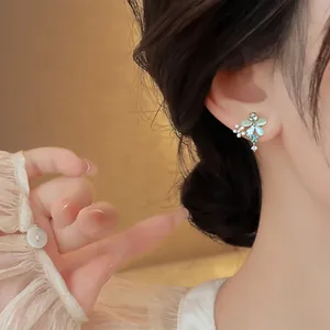 Detail shot of elegant flower butterfly stud earrings with cat-eye stone inlay