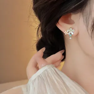 Close-up detail of elegant cat-eye stone and zircon flower butterfly stud earrings