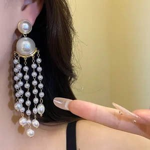 Close-up of elegant French vintage pearl tassel earrings on a model's ear.