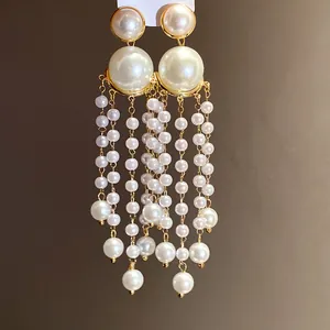 Detailed view of elegant French retro pearl tassel earrings with gold finish and beads.