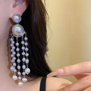 Close-up showing the intricate detail of elegant pearl tassel earrings worn by a model
