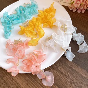 Close-up of elegant chiffon flower tassel earrings with zircon accents in vibrant colors